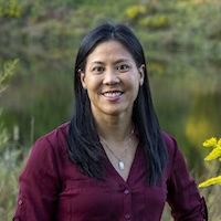 Judy Ledleee standing with a maroon shirt on and smiling at the camera. Ledless is the Executive In Residence, Nicholas School of the Environment and Pratt School of Engineering